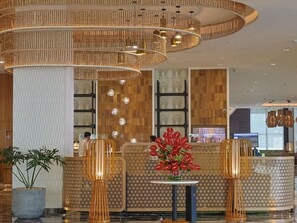 A hotel lobby with a reception desk, patterned walls, and a modern chandelier. - Novotel Hyderabad Airport Hotel (Hyderabad)