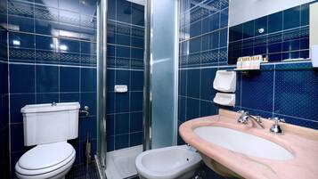 A bathroom with a toilet, bidet, and sink.
