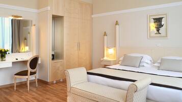 Une chambre d’hôtel avec un lit, un bureau, une chaise et une armoire.