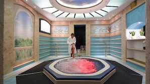 Et spa-rum med jacuzzi, ovenlys og dekorative vægmalerier.