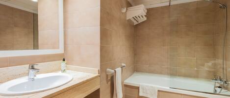A bathroom with a sink, mirror, and bathtub.