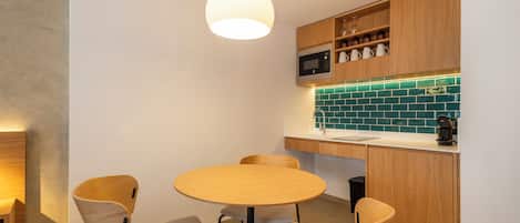 A modern kitchen with wooden cabinets, a round table, and four chairs.