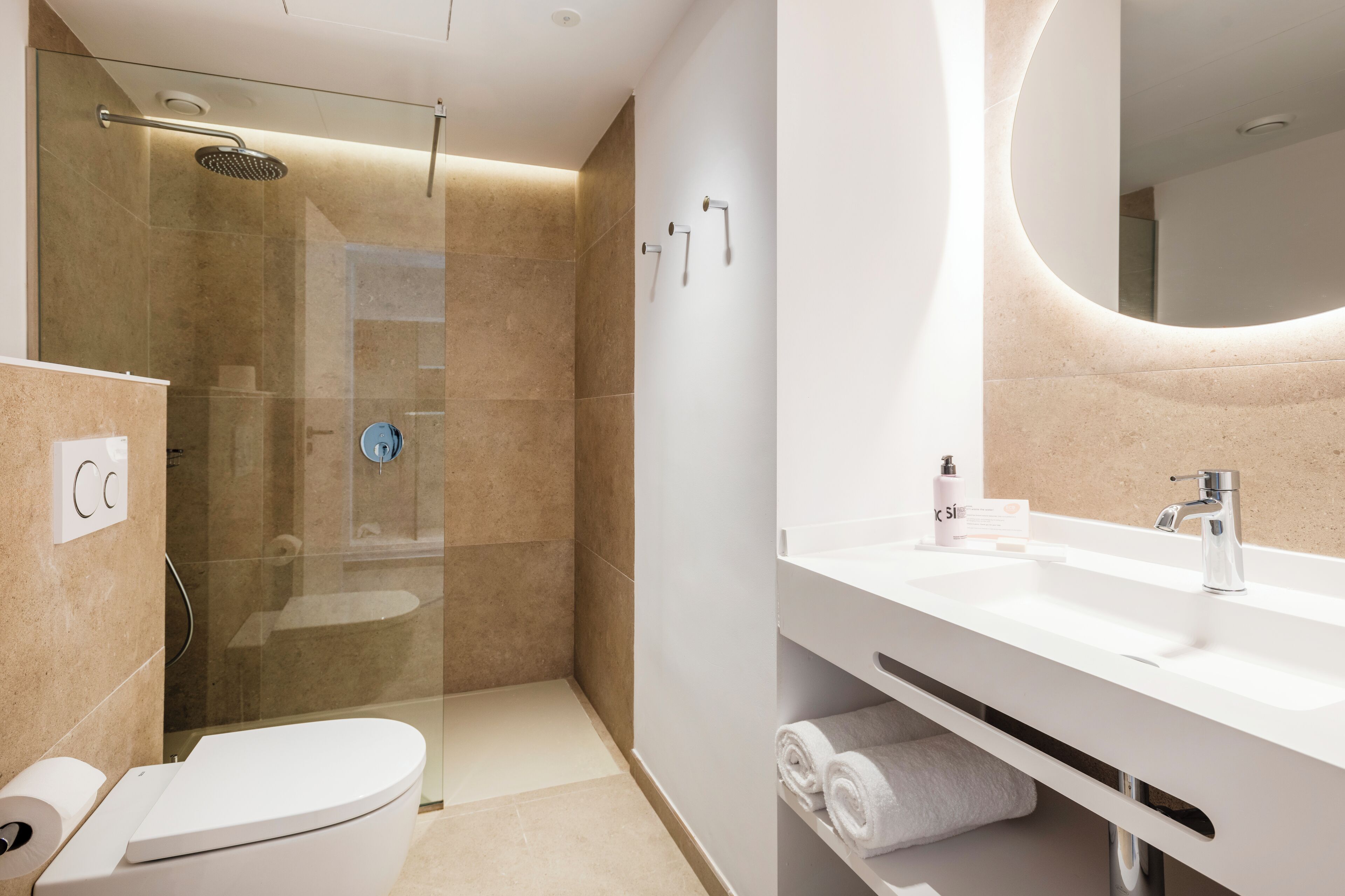 Une salle de bain moderne avec une douche à parois de verre, un lavabo blanc et des toilettes.