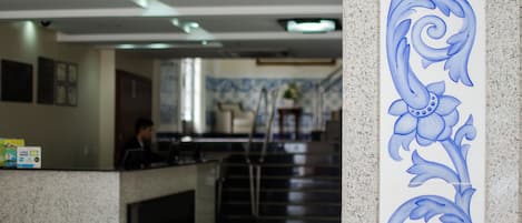 A reception area with a counter, a staircase, and a decorative wall panel.