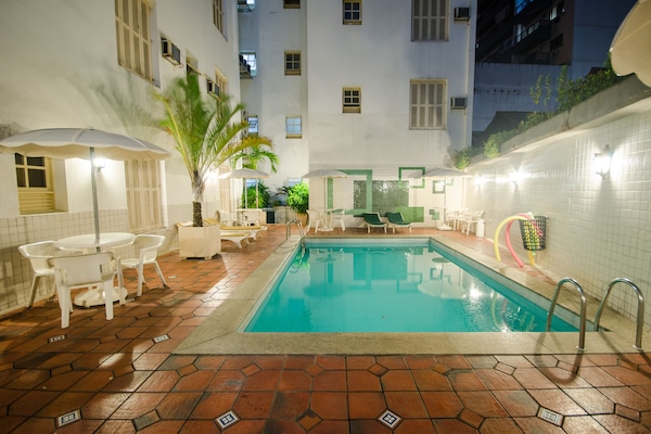 Una piscina al aire libre, sombrillas