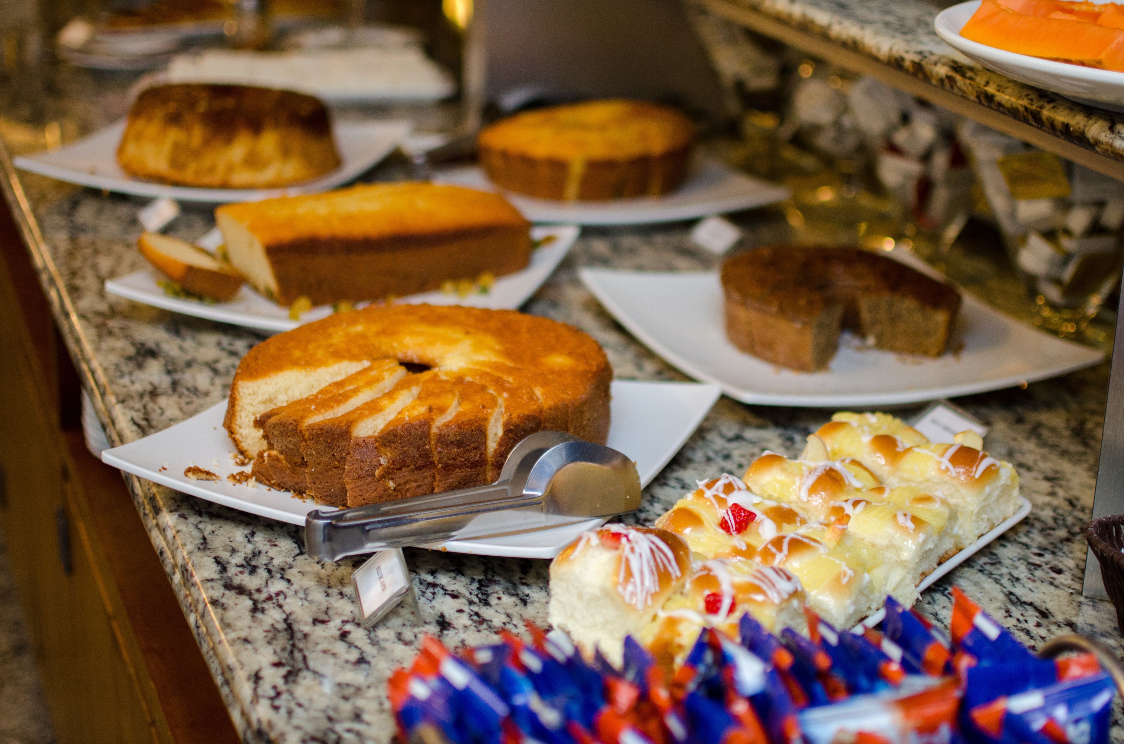 A buffet table with various cakes and pastries.