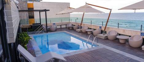 Piscine extérieure, parasols de plage, chaises longues