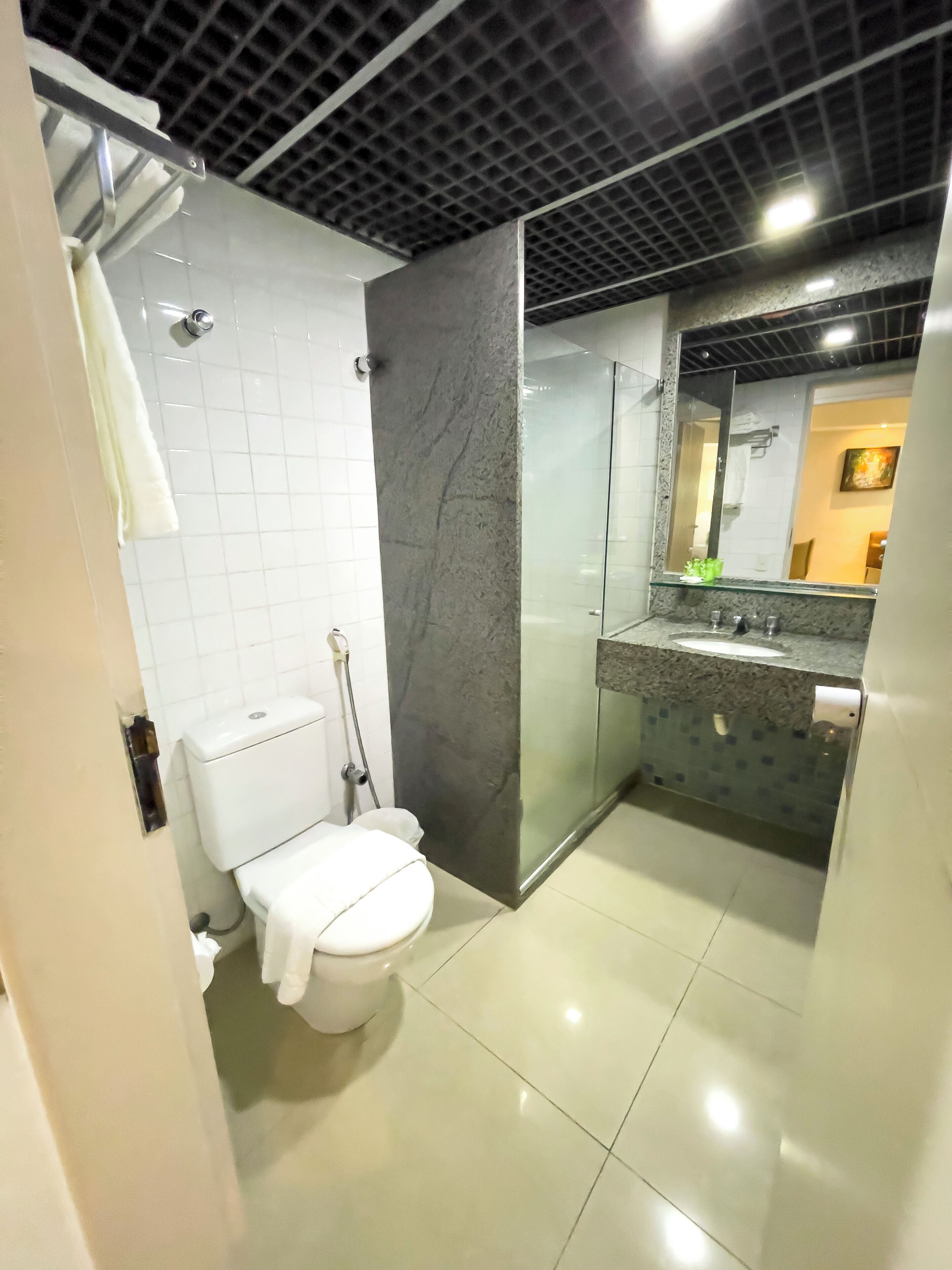 A modern bathroom with a toilet, sink, and shower.