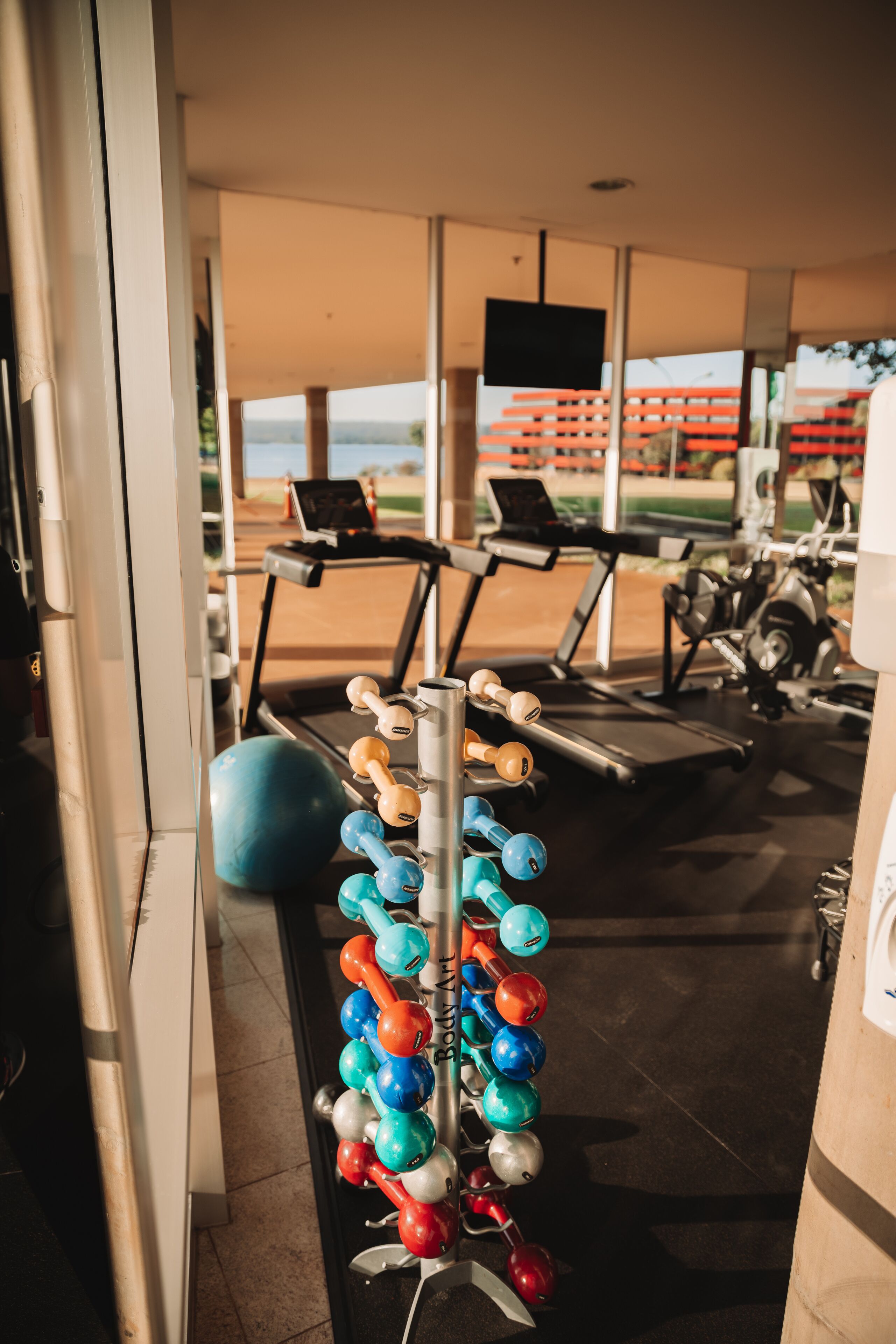 A gym with exercise equipment, including dumbbells and a treadmill.