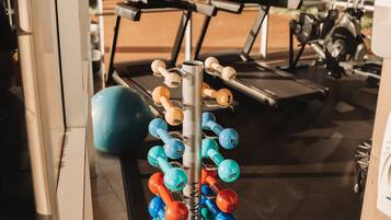 A gym with exercise equipment, including dumbbells and a treadmill.