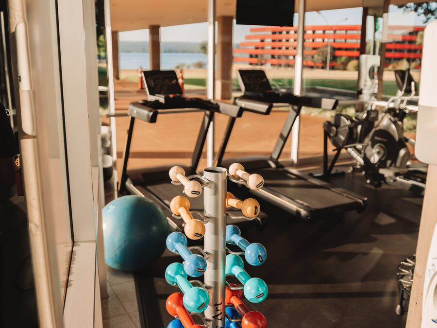 A gym with exercise equipment, including dumbbells and a treadmill.