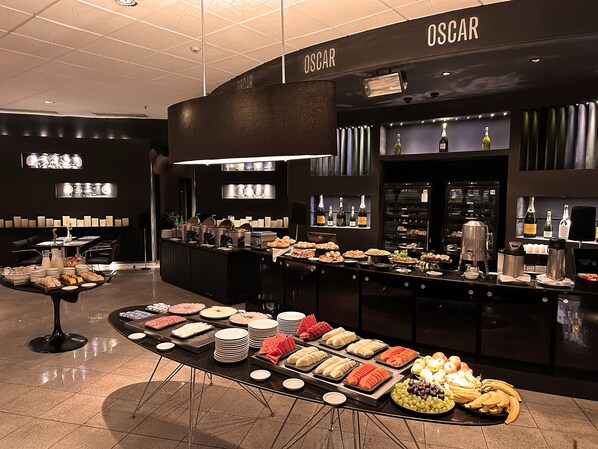 A buffet area with various food items and a selection of wines.