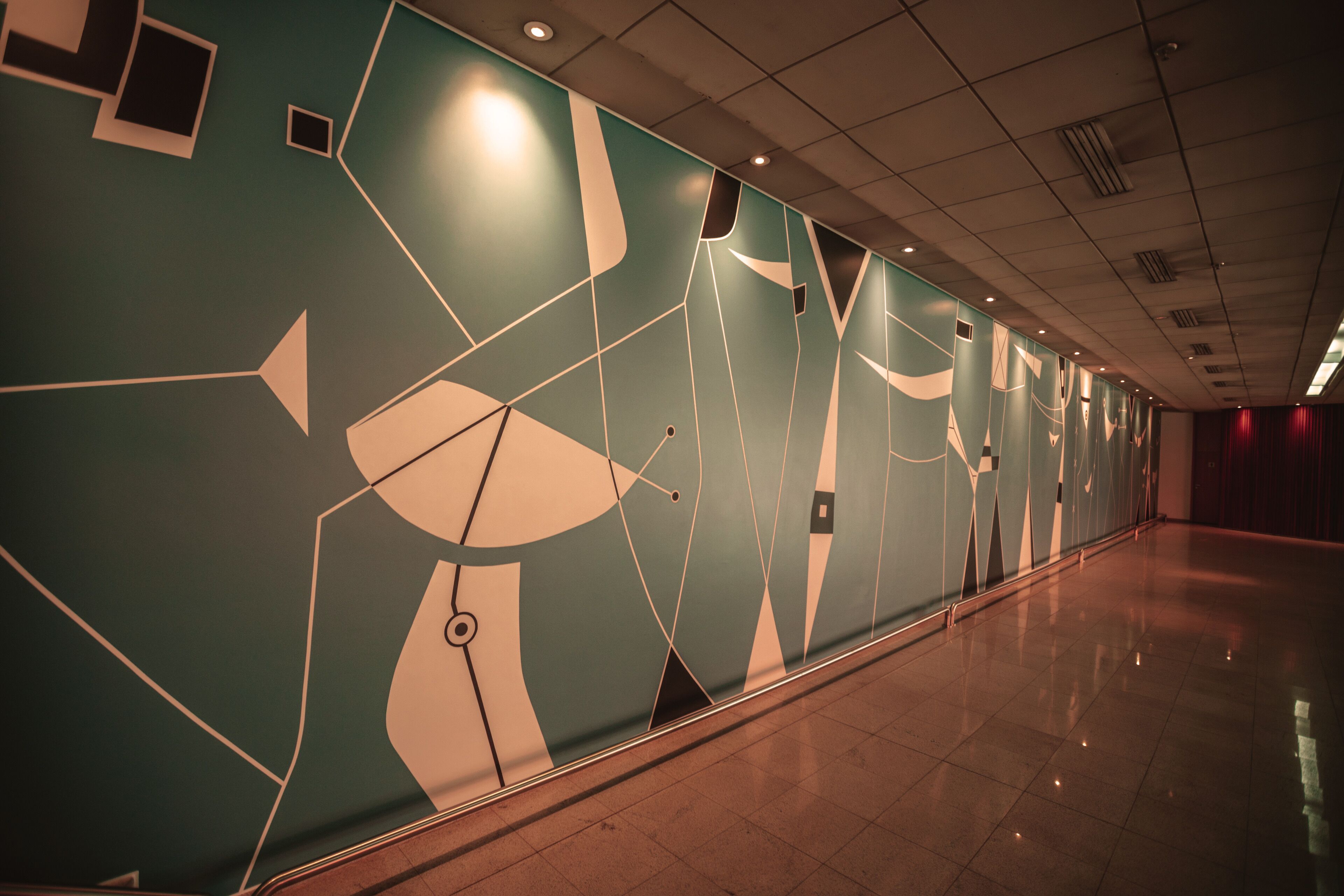 A hallway with a geometric wall design and a polished floor.