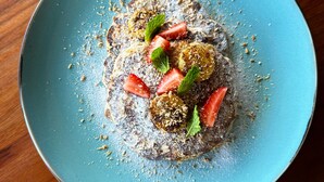 A blue plate with a dessert on a wooden table.
