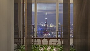 A room with large windows overlooking a cityscape, including a prominent tower. - Park Hyatt Shanghai (Shanghai)