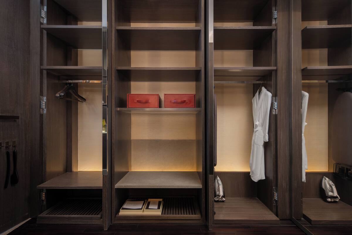 A walk-in closet with multiple shelves, a hanging rack, and a shoe rack.
