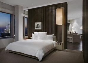 A modern hotel room with a large bed, a city view, a desk, and a mirror. - Park Hyatt Shanghai (Shanghai)