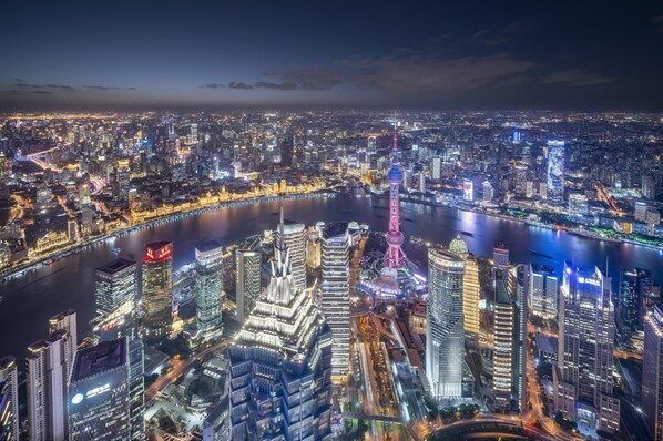 A nighttime cityscape with a river, illuminated buildings, and a prominent tower. - Park Hyatt Shanghai (Shanghai)