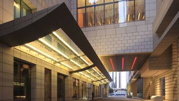 Un bâtiment moderne doté d’une façade en verre, d’une galerie couverte et d’un mur en briques.