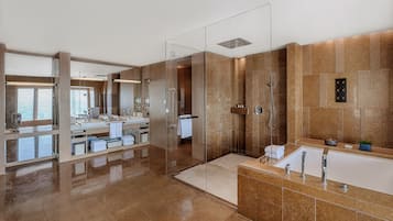 Un baño moderno con ducha envuelta en vidrio, tocador grande con bañera y espejo sobre el lavabo.