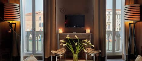 A modern living room with a fireplace, a flat-screen TV, and two chairs.