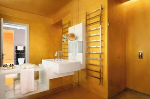 Un bagno moderno con lavandino, specchio e portasciugamani bianchi.