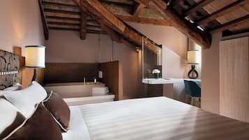 Un dormitorio con una cama grande, techo de madera, baño con espejo y ventana.