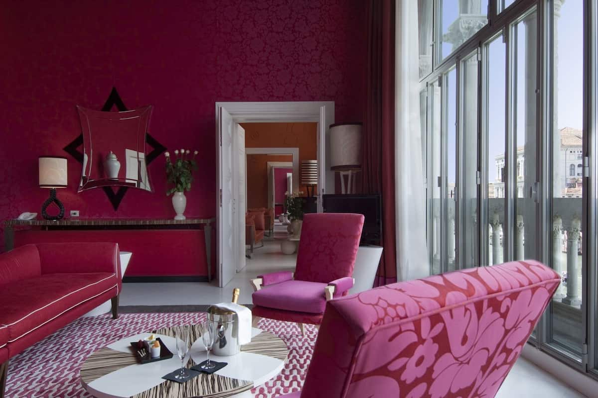 Una sala de estar moderna con alfombra roja, un ventanal y vista a la ciudad.