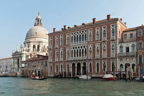 A historic building with a dome, arched windows, and a canal with gondolas. - Sina Centurion Palace (Venice)
