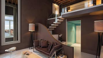 A modern interior with a curved sofa, a glass staircase, and a view of a cityscape through a window.
