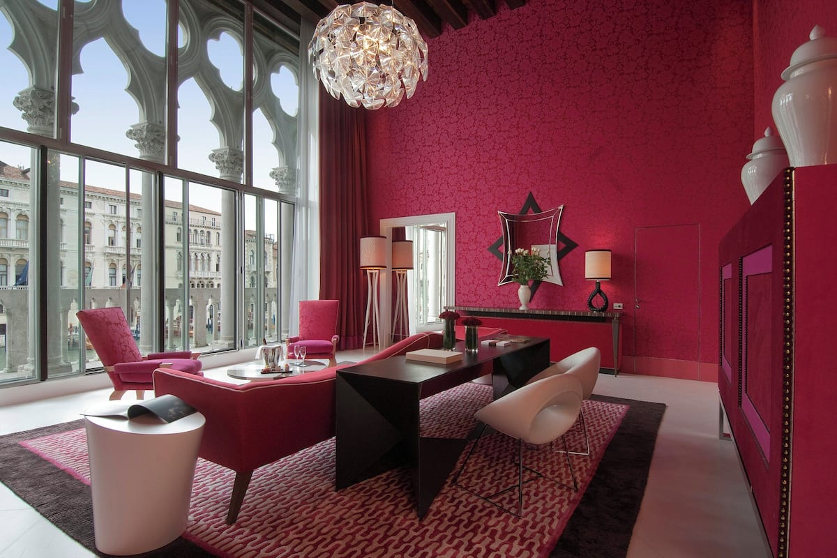 Un interior moderno con un ventanal grande, una zona de comedor y vistas a un edificio.