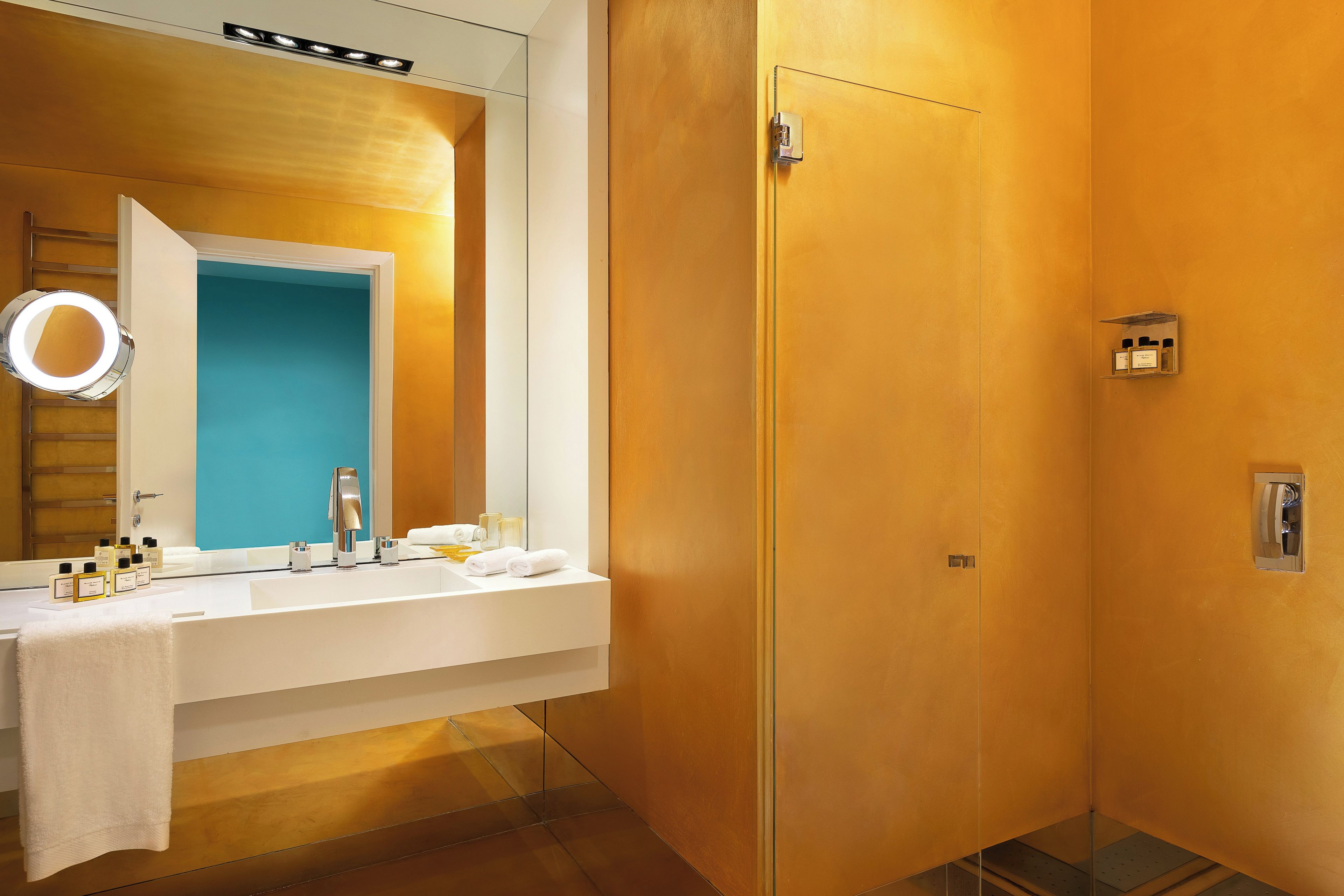 A modern bathroom with a white vanity, a mirror, and a shower area.