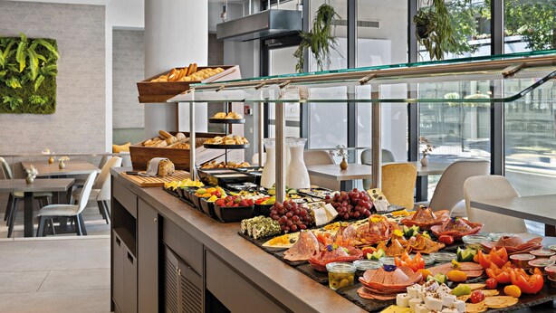 A buffet with a variety of food items including fruits, cheeses, meats, and breads. -  Leonardo Hotel Salzburg City Center (Salzburg)