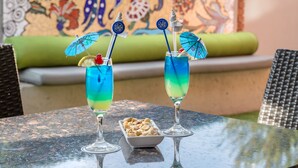 Zwei Cocktails auf einem Tisch, im Hintergrund eine farbenfrohe Wandmalerei.