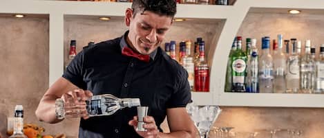 A bartender pouring a drink into a glass.