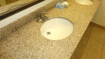 A bathroom with two sinks, each with a faucet and a tissue box.