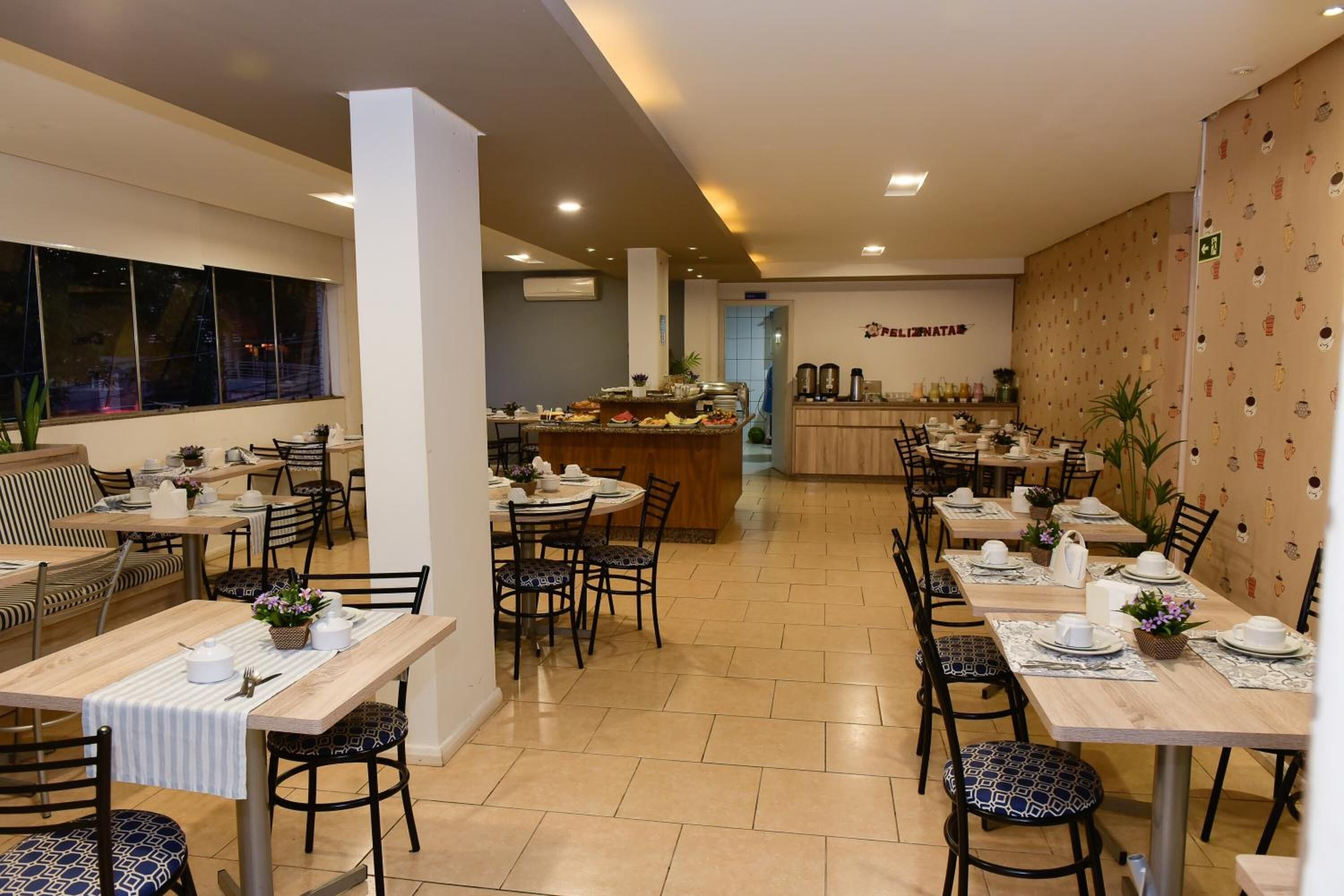 Un restaurante con varias mesas, sillas y una zona de bufé.