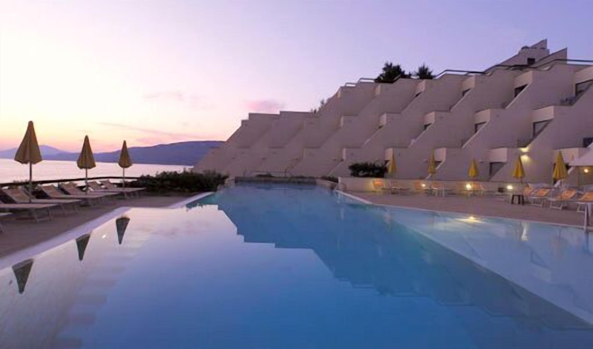 Una piscina moderna con lettini e ombrelloni, immersa in un design architettonico originale.
