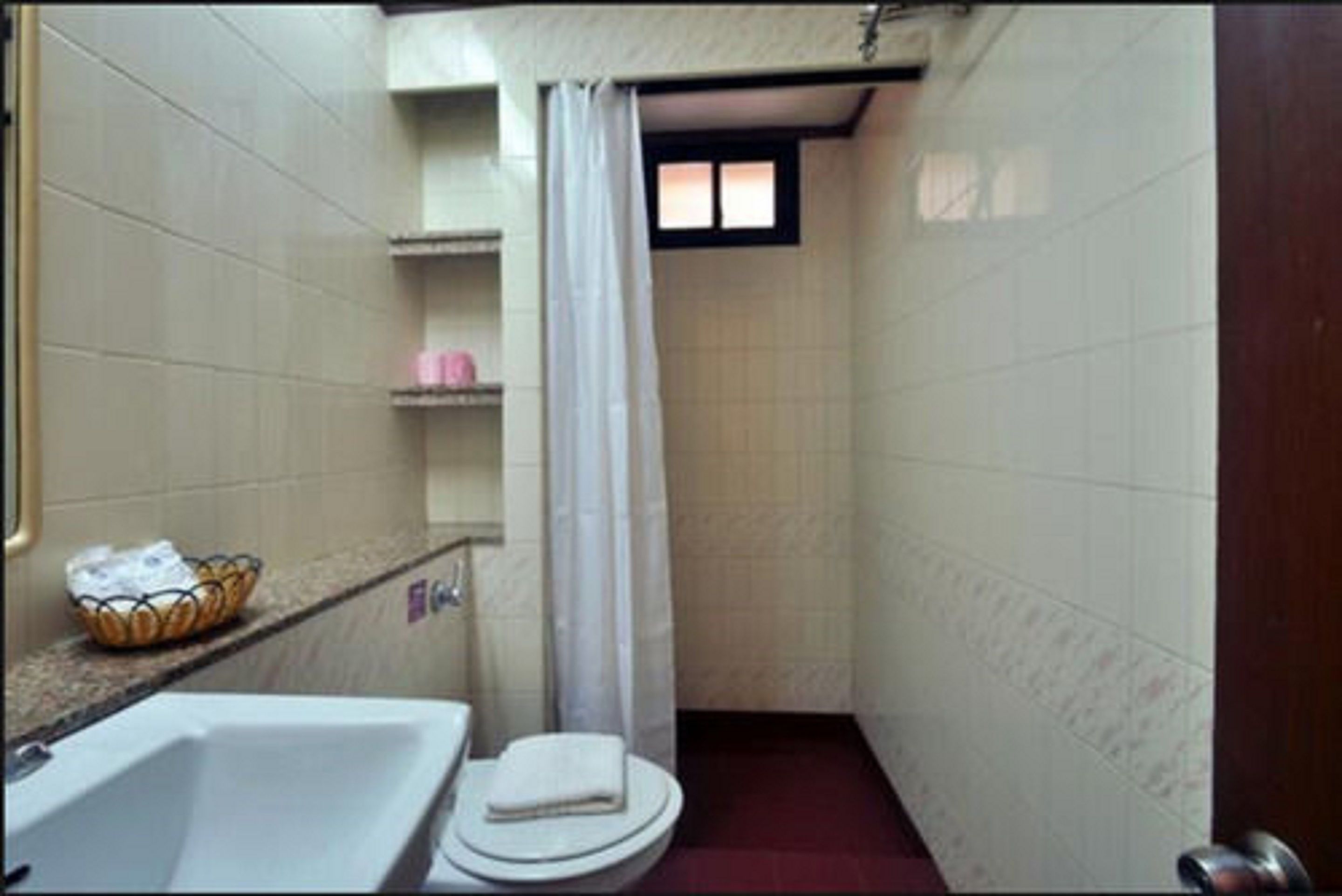 Une petite salle de bain avec une baignoire, des toilettes et un rideau de douche.