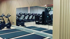 A gym with exercise equipment including treadmills and a weight machine. - The Lensbury Resort (Teddington)