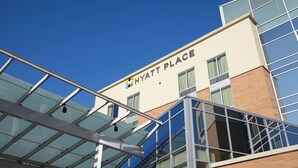 Un edificio moderno con fachada de vidrio y un cartel que dice 'HYATT PLACE'.