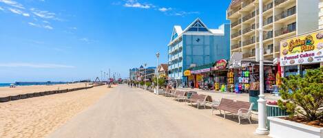 Une promenade en bord de mer bordée de boutiques, dont une boulangerie et un magasin de vêtements.