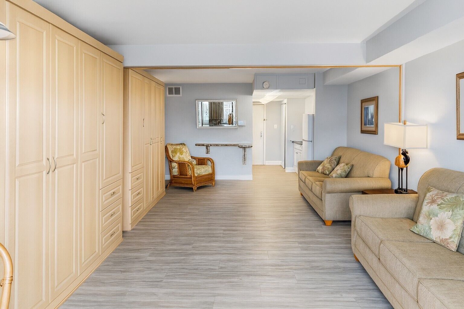 A spacious living area with a sofa, a chair, and a wardrobe.