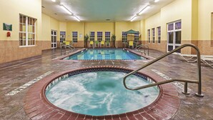 A large indoor swimming pool with a hot tub, surrounded by lounge chairs and a covered seating area. - La Quinta Inn & Suites by Wyndham Eastland (Eastland)