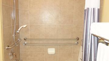 A bathroom with a shower, grab bars, a toilet, and a bathtub.