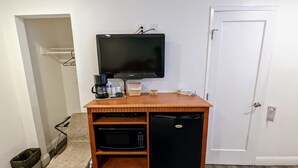 A compact kitchenette with a microwave, coffee maker, and a small refrigerator. - Deluxe Inn (South San Francisco)
