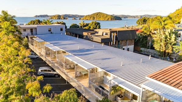 Un hotel moderno con varios balcones que dan a un puerto deportivo y una bahía.