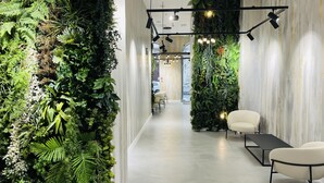 Un interior moderno con un jardín vertical, un largo pasillo y una zona de estar de diseño minimalista.