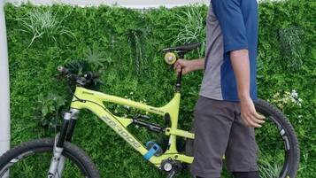 Een persoon staat naast een gele fiets, met 'pinion' en 'zerode' op de frame zichtbaar.