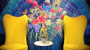 Two yellow armchairs facing each other with a table between them, set against a vibrant, colorful wall mural. - JetPark Hotel Rotorua (Rotorua)